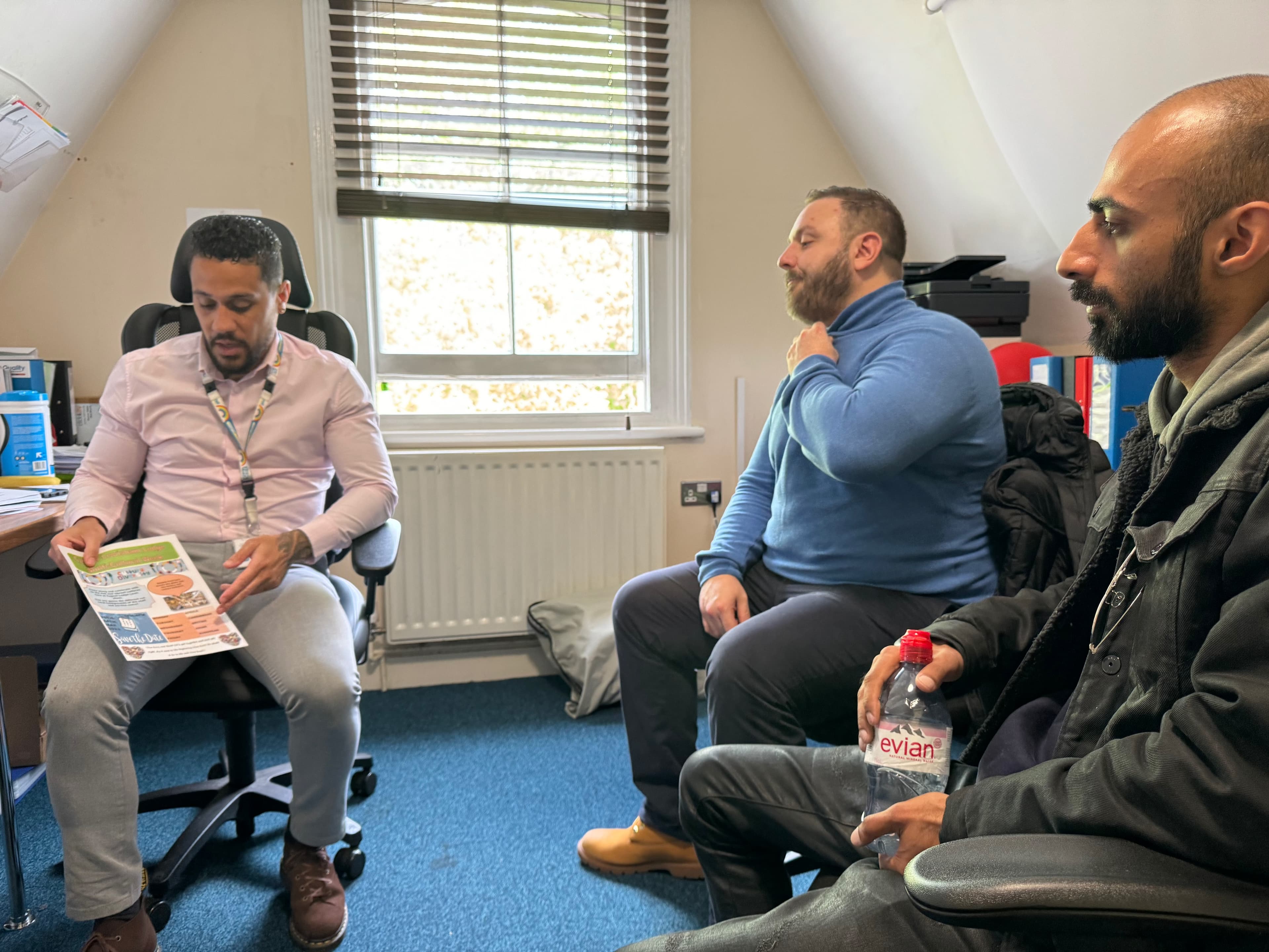 Three people reviewing a printed document during a meeting.